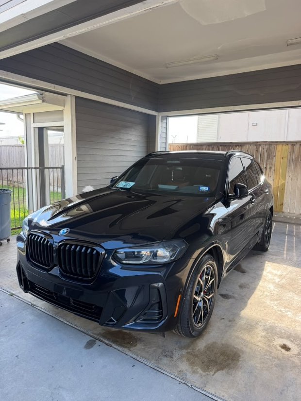 Black BMW X3 SUV parked in garage after mobile auto detailing service