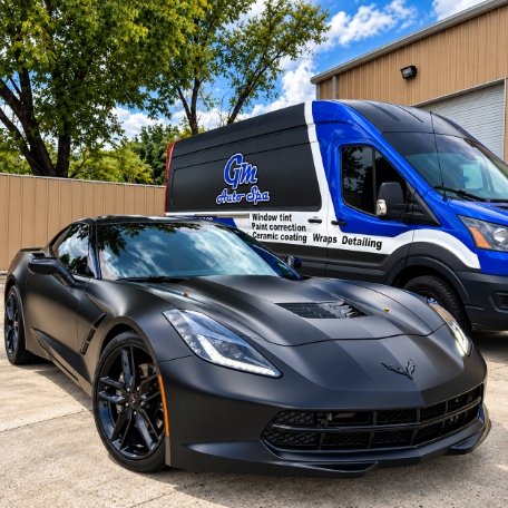 Matte black Chevrolet Corvette parked next to GM Auto Spa mobile detailing van