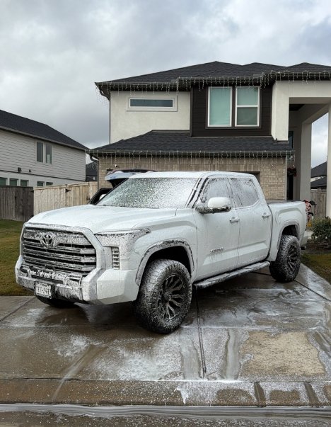 White Toyota Tundra truck covered in active snow foam during driveway mobile detailing